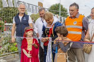 Madame la maire Elisabeth Guiheneux avec deux enfants en costume moyenâgeux, coupe le ruban pour l'inauguration du marché des enfants. Samedi 4 septembre 2021, La Guerche De Bretagne.