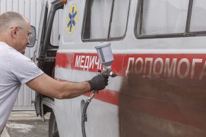 Un garagiste récupère des voitures civiles, pour les transformer en véhicules militaires en les repeignant aux couleurs de l'armée Ukrainienne - Kyiv (Kiev) juillet 2022.