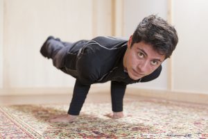 Un homme qui fait de la méditation yoga avec une pose en regardant la caméra