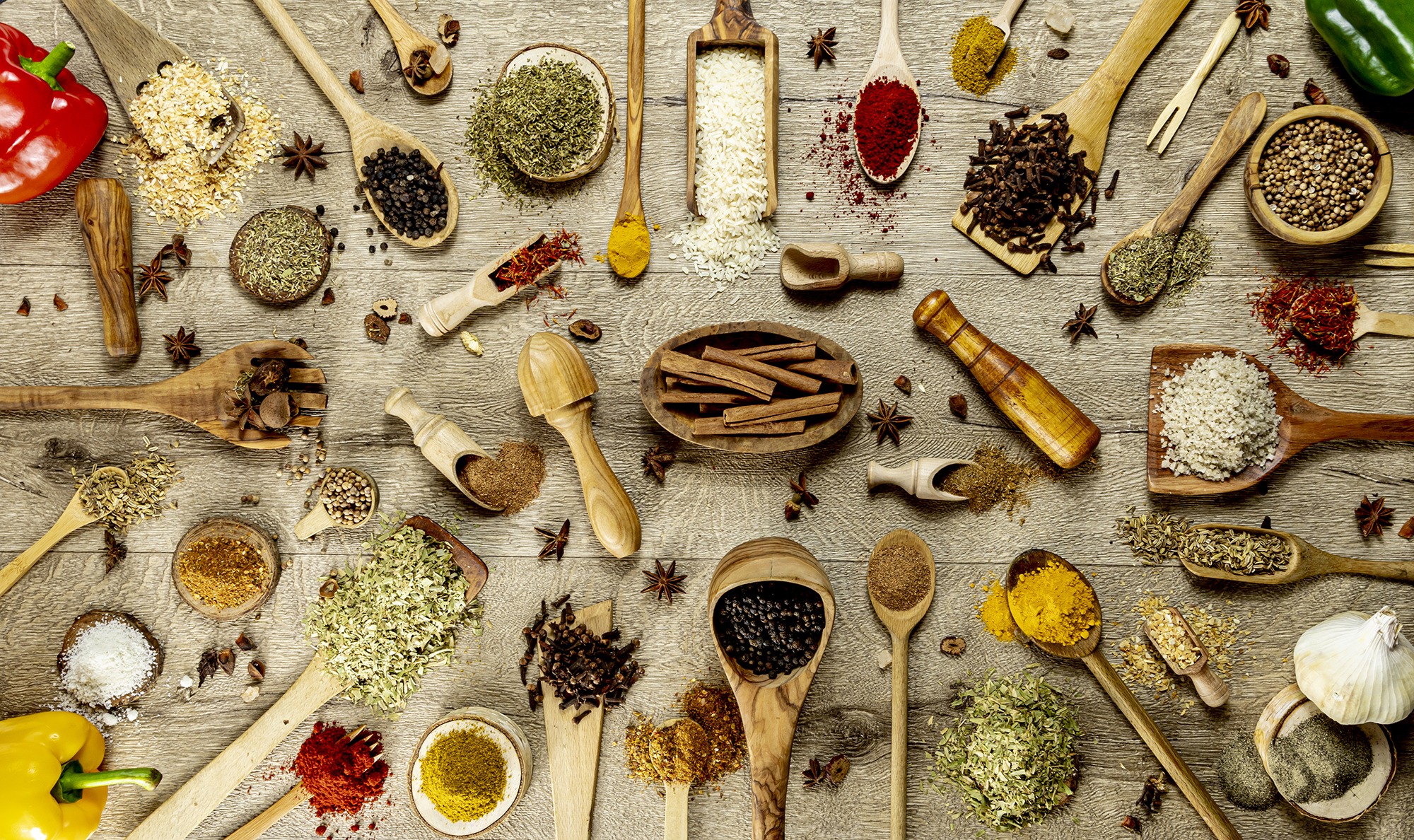 Big set of Indian and orientals spices and herbs with wooden spatulas. On a wooden table. March 2023