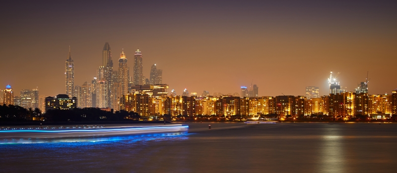 Dubai by night: building, roads and lifestyle with colorful lights.