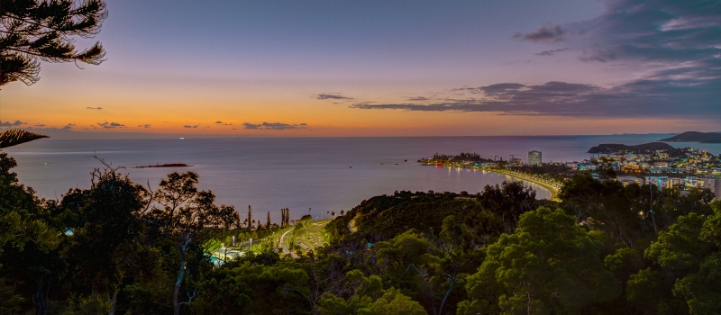 Paysage de la ville de Nouméa en Nouvelle Calédonie. Vue depuis le parc municipal Ouen Toro en fin de journée durant la blue hour et une partie de la sunset hour. Vue sur la baie de Anse Vata et la plage de la baie des citrons.